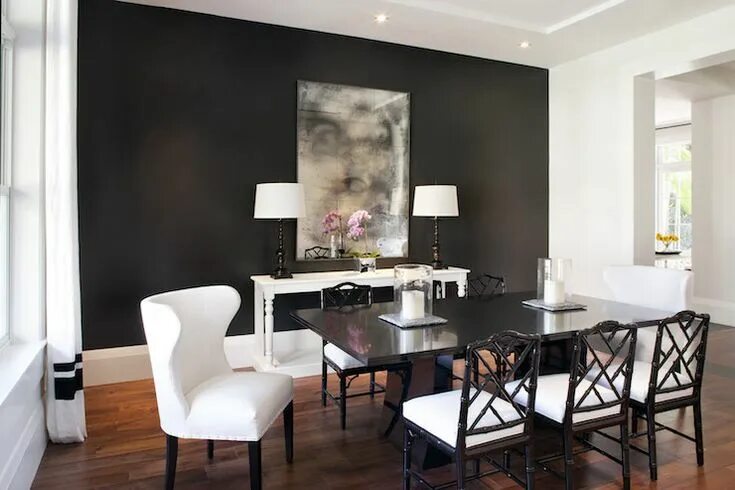 Акцентная стена в интерьере 2024 Table lined with black bamboo dining chairs against a dramatic accent wall paint