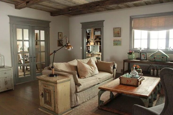 Кантри в интерьере квартиры mobilier de récup en bois et canapé rembourré taupe dans le salon de style maiso
