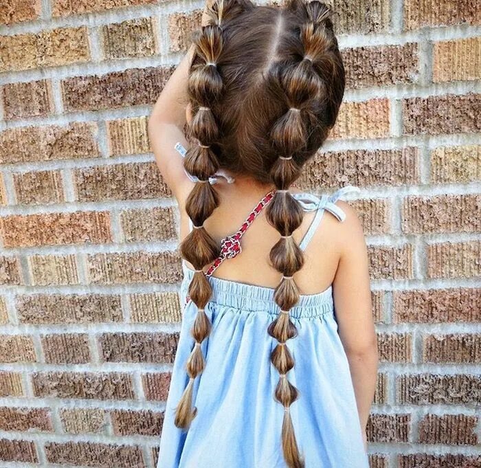 Красивые прически восьмилетняя many rubber hairbands, decorating the two long pigtails, of a small child, in a 