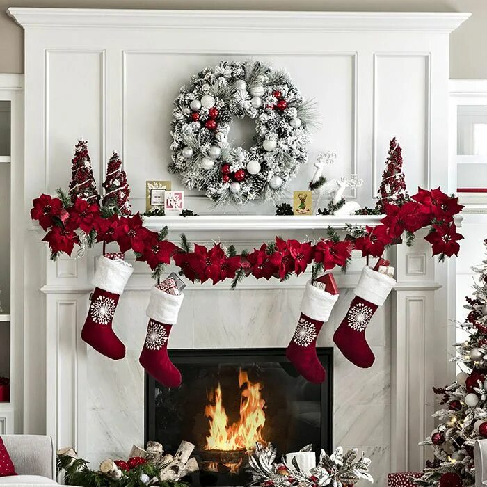 Красивый новогодний декор Big Fireplace with snow flocked wreath, christmas flowers garland and stockings.