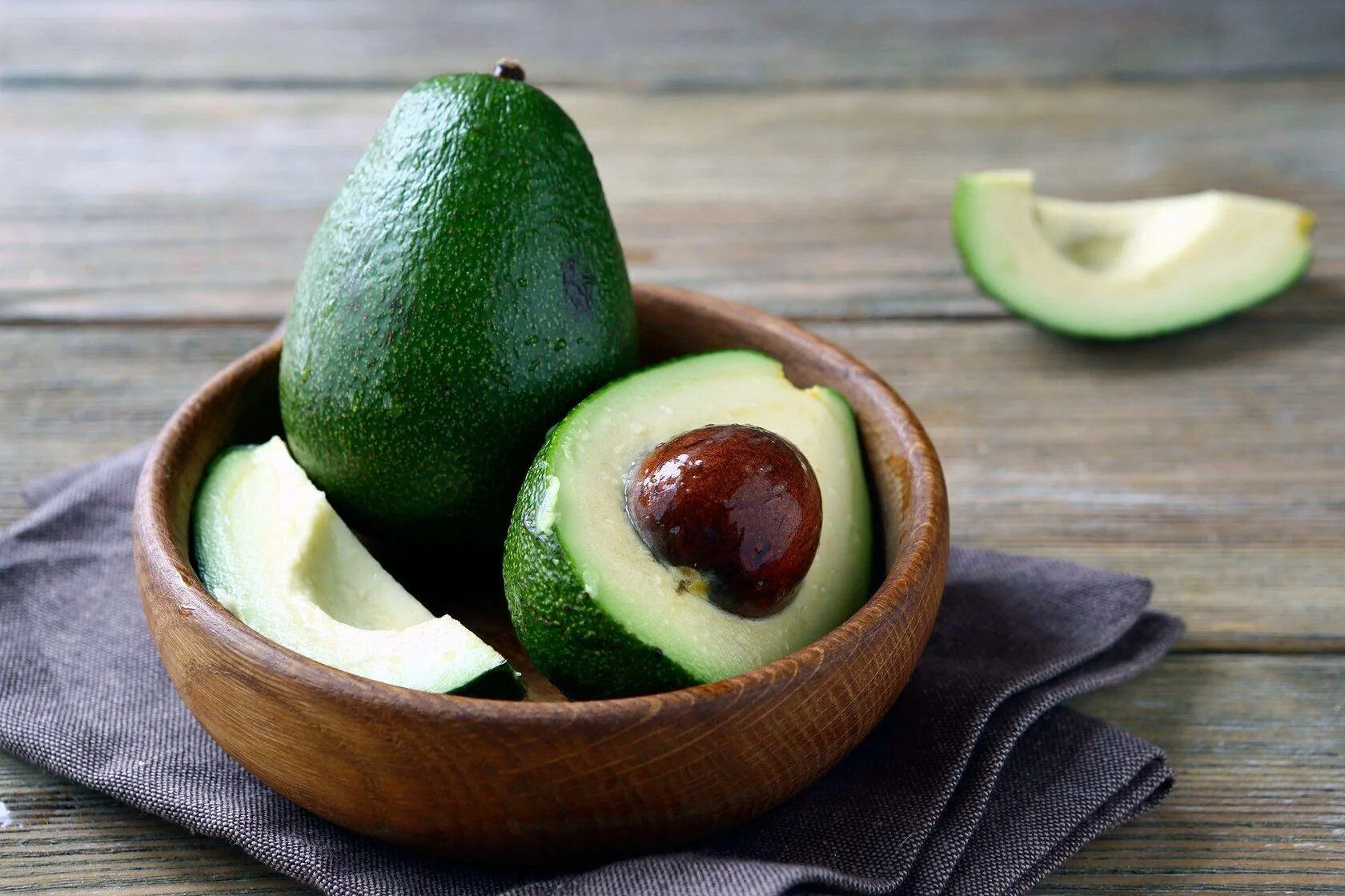 Красное авокадо фото Download Fresh Avocado Fruit On Wooden Plate Wallpaper Wallpapers.com