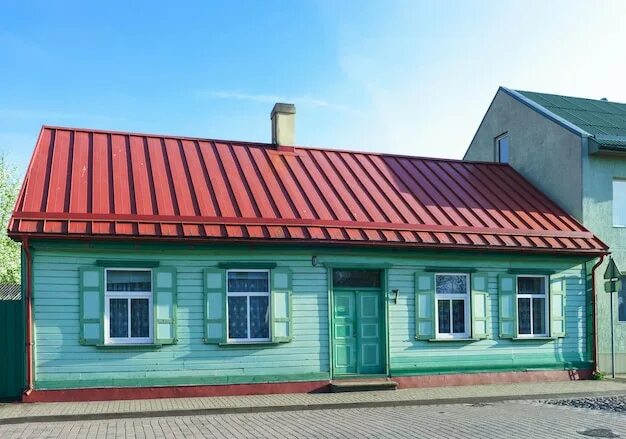 Красный дом с зеленой крышей фото Старый деревянный дом, окрашенный в зеленый цвет с красной крышей, в вентспилсе,