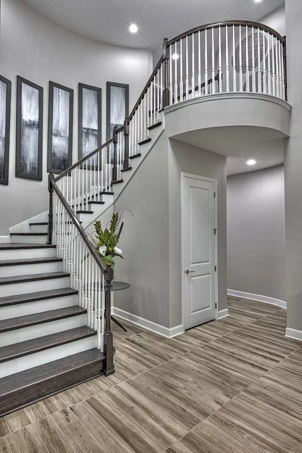 Лестница в сером цвете в интерьере A dramatic staircase welcomes guests to this exquisite home in Orlando, FL Harmo