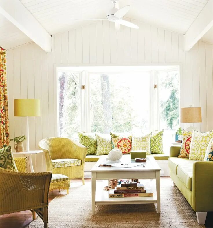 Летний интерьер комнаты A fresh livingroom decoration with white timber walls, wicker chairs and full of