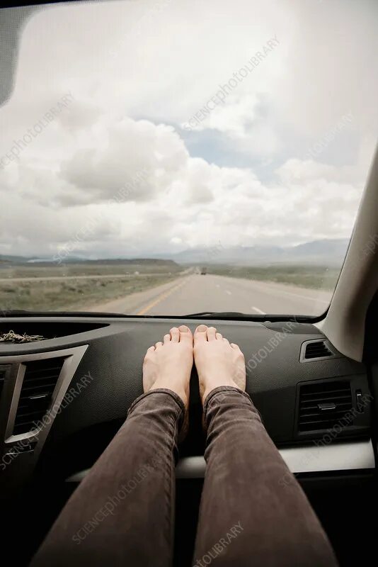 Минут в машине фото A woman in a car with bare feet on the dashboard - Stock Image - F017/6424 - Sci