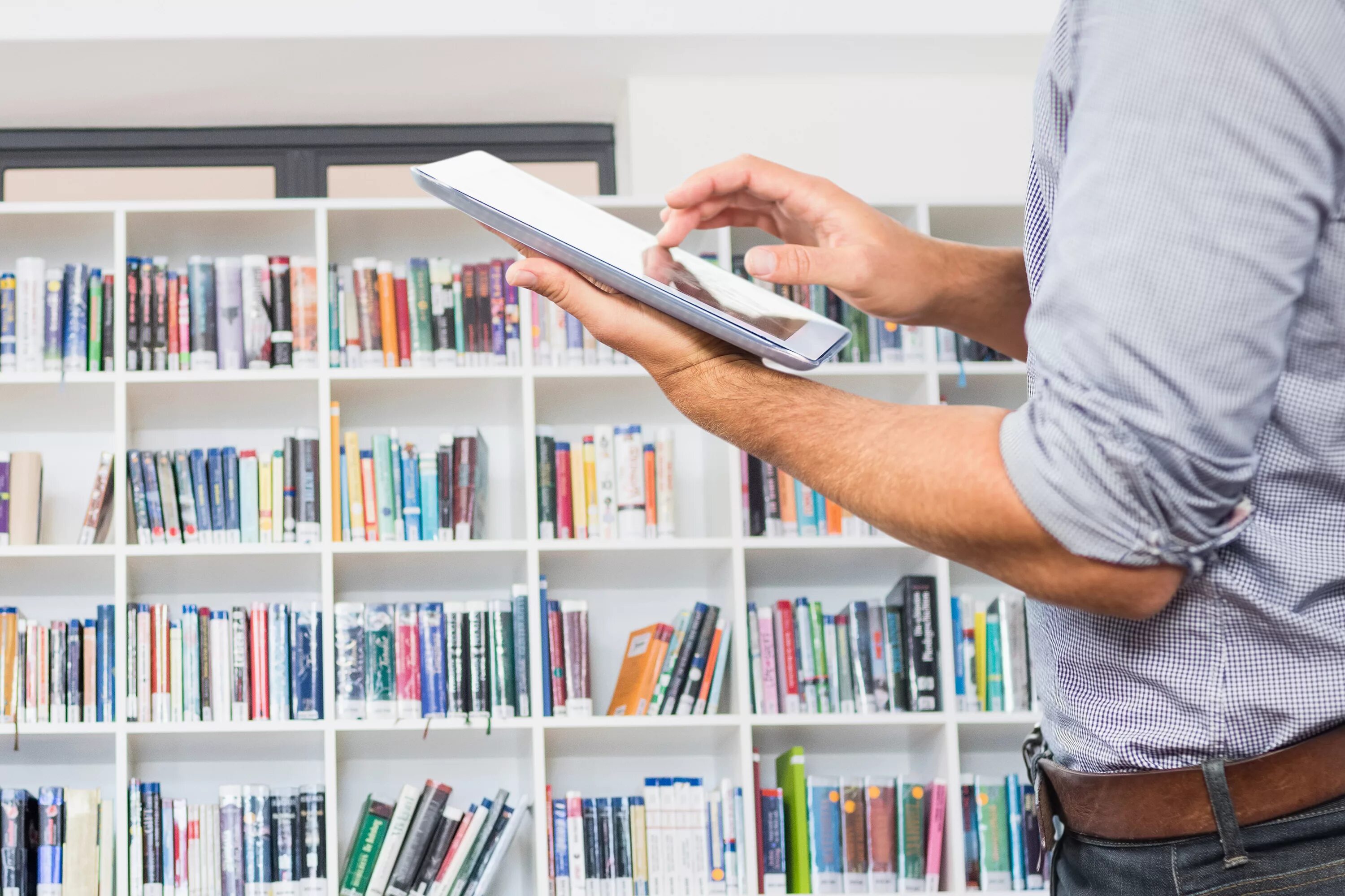 Оценка книг онлайн по фото Composite image of man holding digital tablet with library background - Somerset