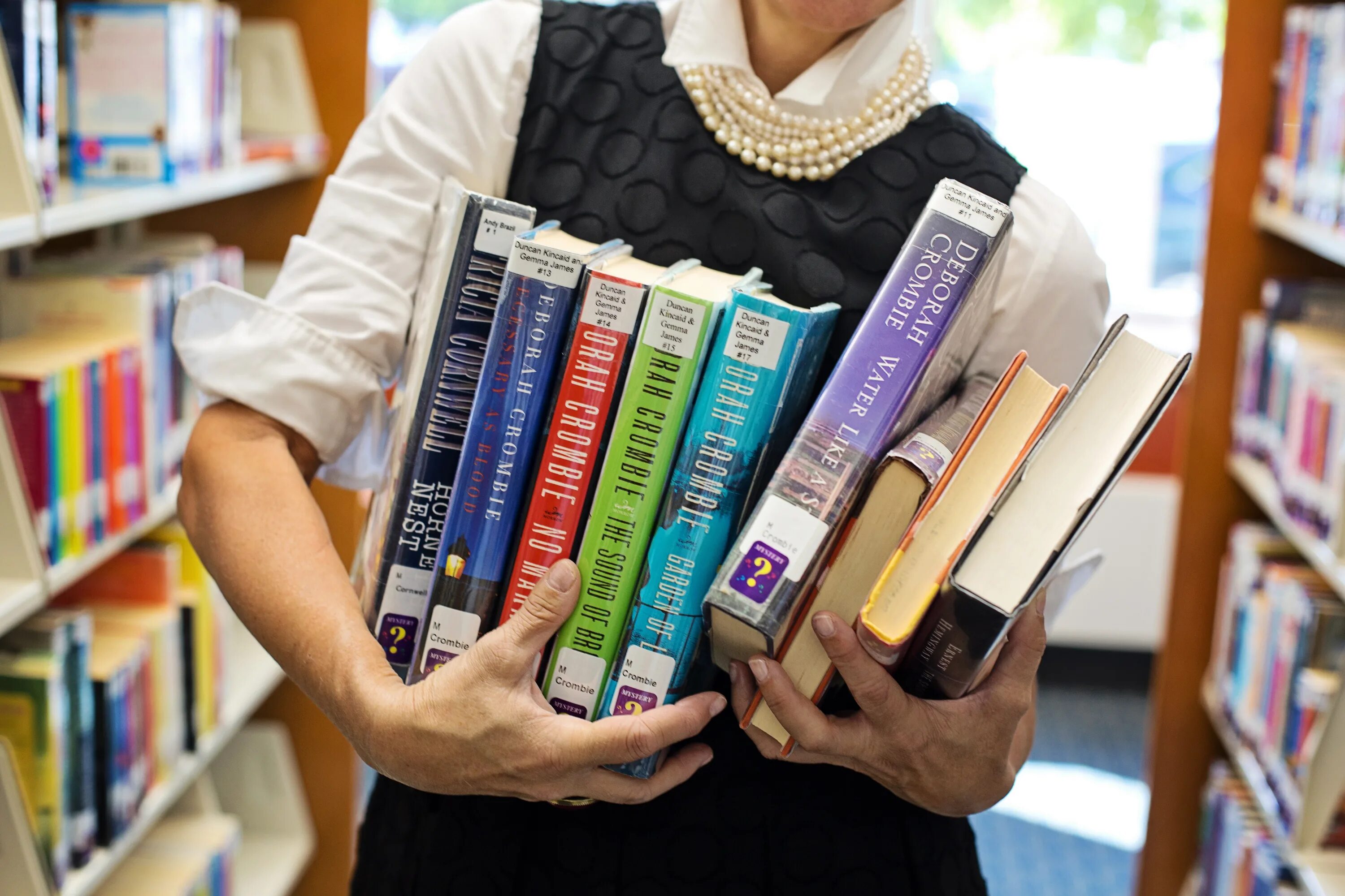 Оценка книг по фото Woman with books in library close up on blurred background free image download