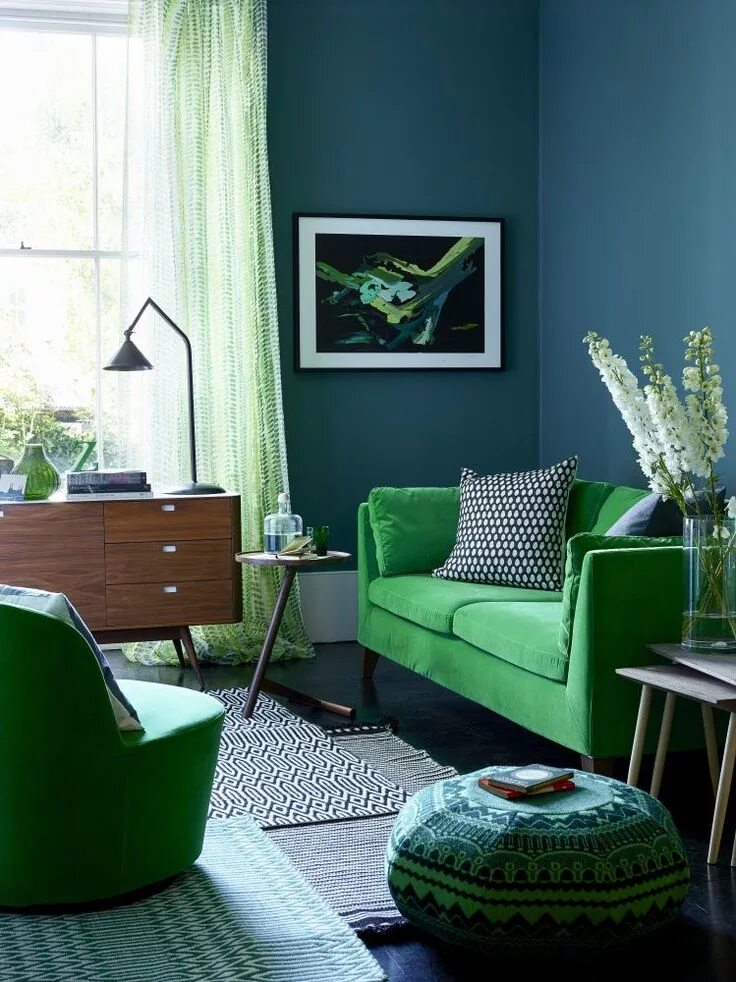 Оттенки зеленого цвета в интерьере Team a sumptuous sofa with teal walls and dark wood retro-style furniture. Smart