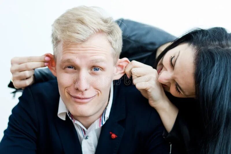 Оттягивать за уши парня девушку фото Girl Pulling Boyfriend`s Ears To Make a Fun - Smiling Face Grimace Stock Photo -