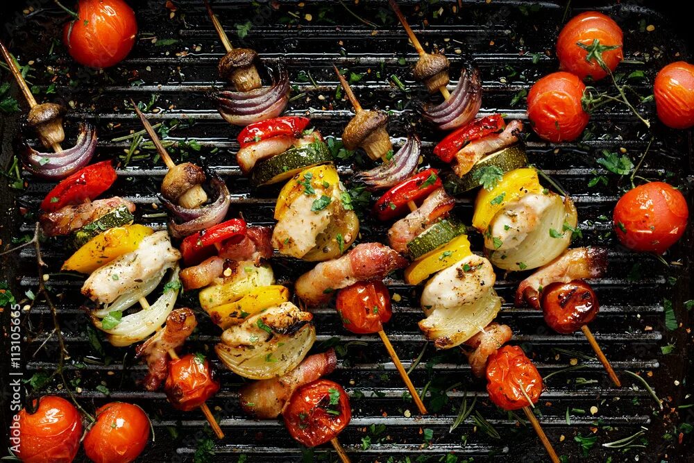 Овощи на мангале на шампурах фото Grilled vegetable and meat skewers in a herb marinade on a grill pan, top view Ф