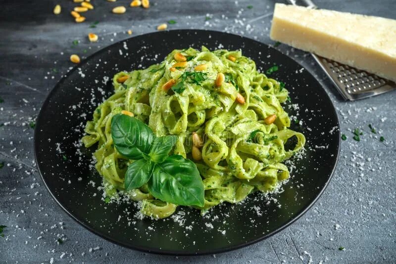 Паста с соусом рецепты с фото Tagliatelle Pasta with Pesto Sauce, Pine Nuts and Parmesan on Black Plate. Stock