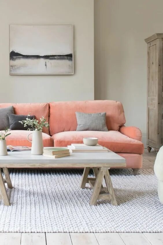 Персиково серый интерьер a welcoming living room with dove grey walls, a coral pink sofa, a concrete coff