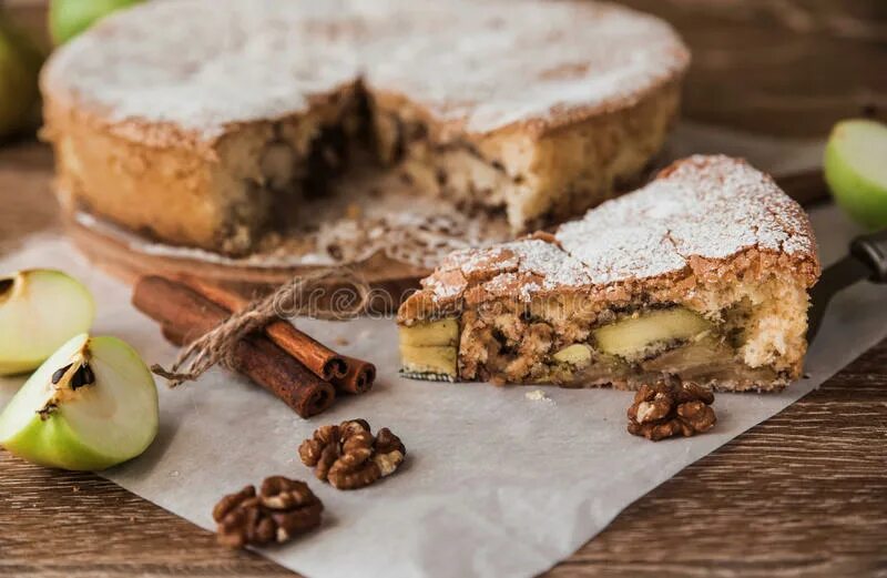 Пироги с корицей с фото Piece of Apple Pie with Cinnamon and Walnuts on a Wooden Table Stock Photo - Ima