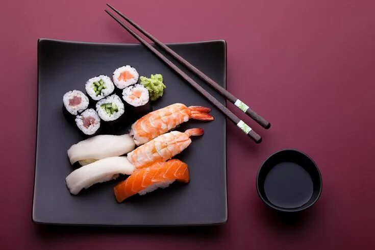 Подпись к фото суши Sushi and Chopsticks on a Black Plate