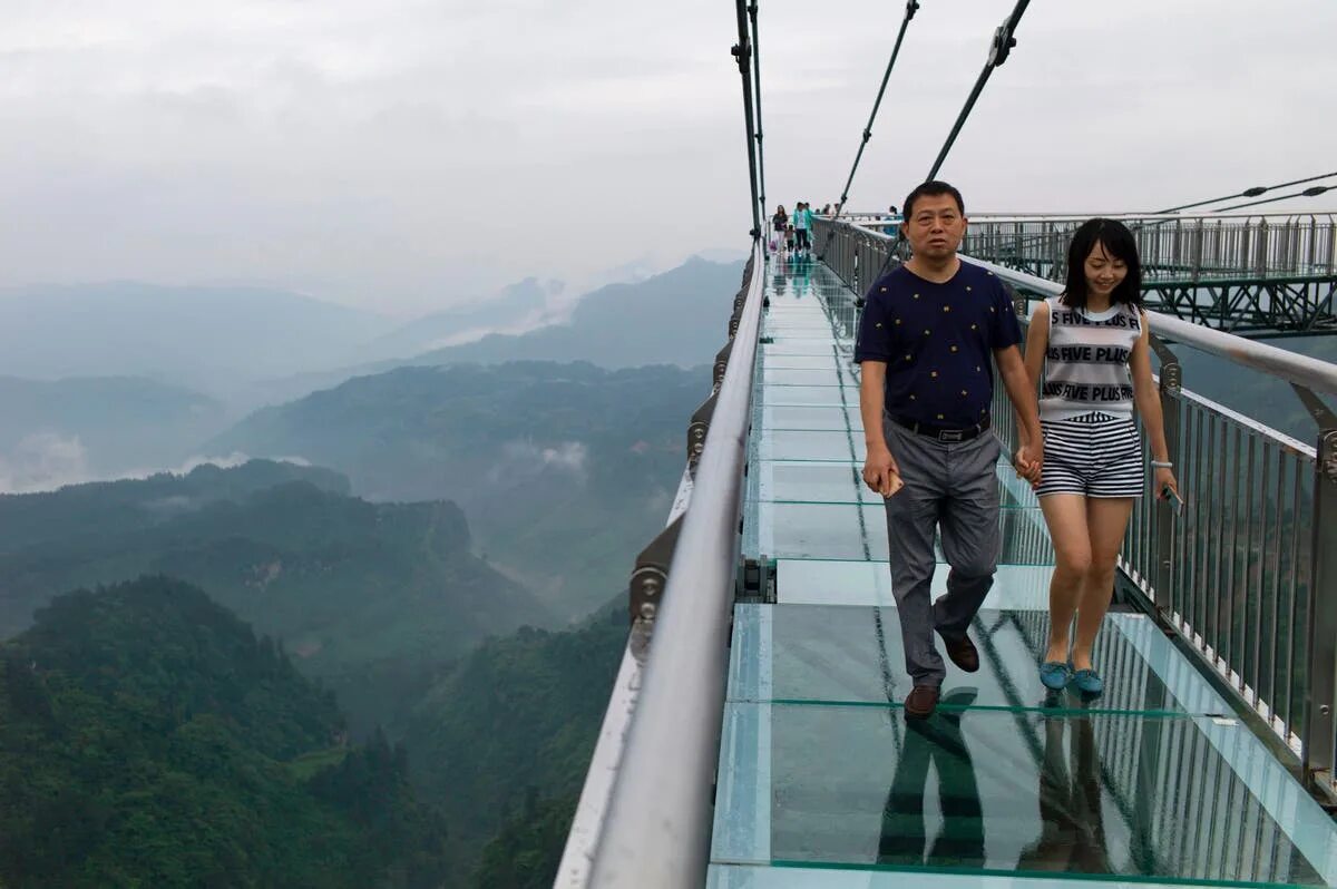 Подписать фото на стеклянном мосту в китае Panels on Chinese glass bridge fall out during gale-force winds, leaving tourist