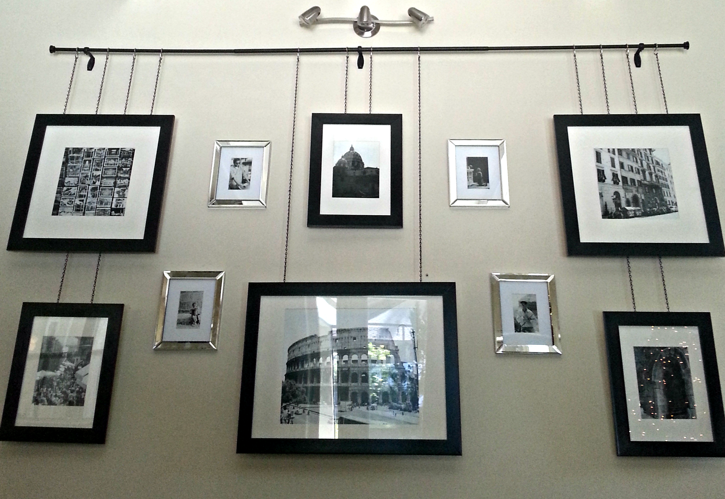 Подвесная система для фото Gallery frames hanging by chain from a curtain rod with contrasting frames on wa