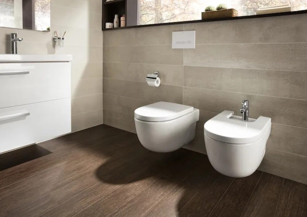 Wall hung toilet pan, raised flooring into the room, with chrome edging bead to 