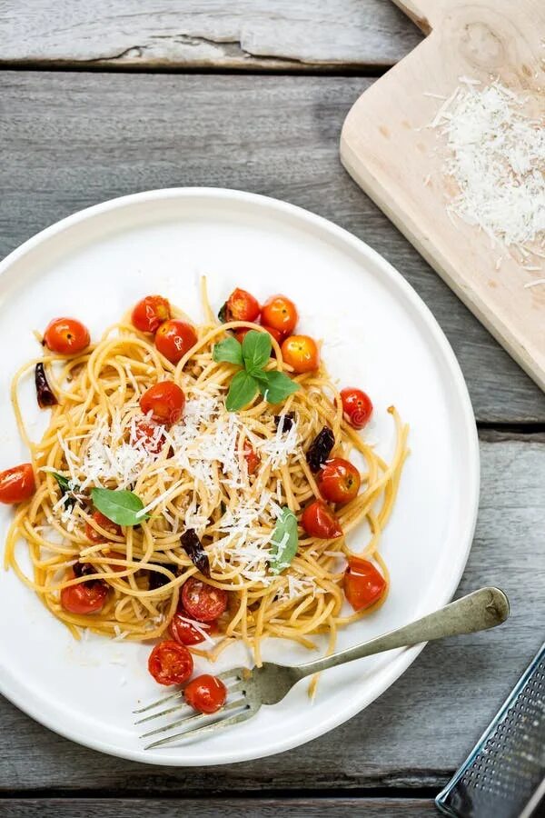 Помидоры спагетти фото Spaghetti with Cherry Tomatoes and Dried Chili with Grated Parmesan Stock Image 