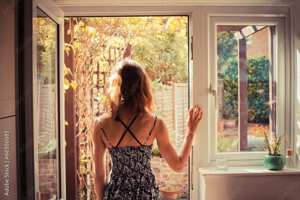 Посмотрела окно фото Woman standing in doorway at sunrise фотография Stock Adobe Stock