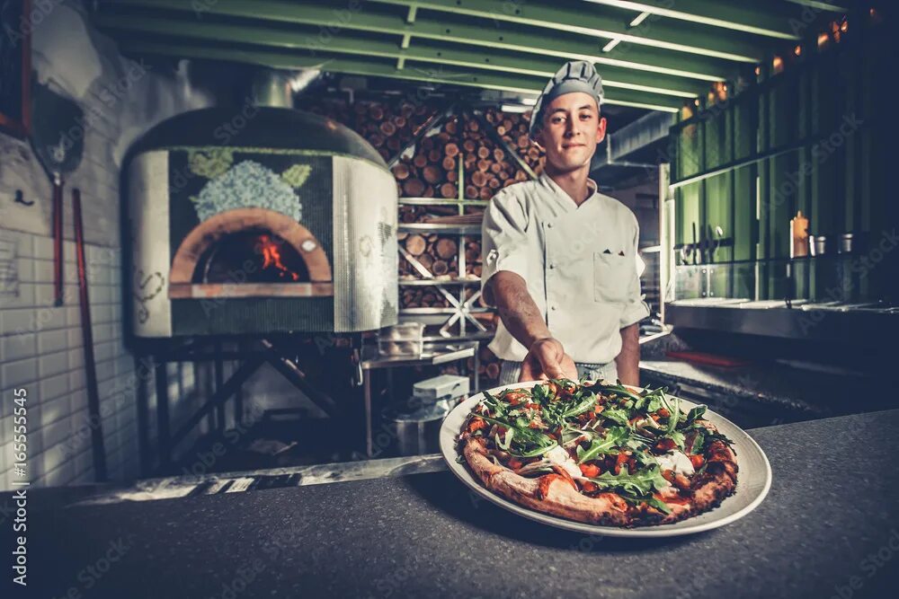 Повар пиццы фото Food concept. Preparing traditional italian pizza. Young smiling chef in white u