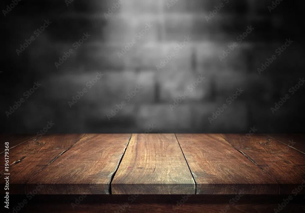 Поверхность стола фото Old wood table with blurred concrete block wall in dark room background. фотогра