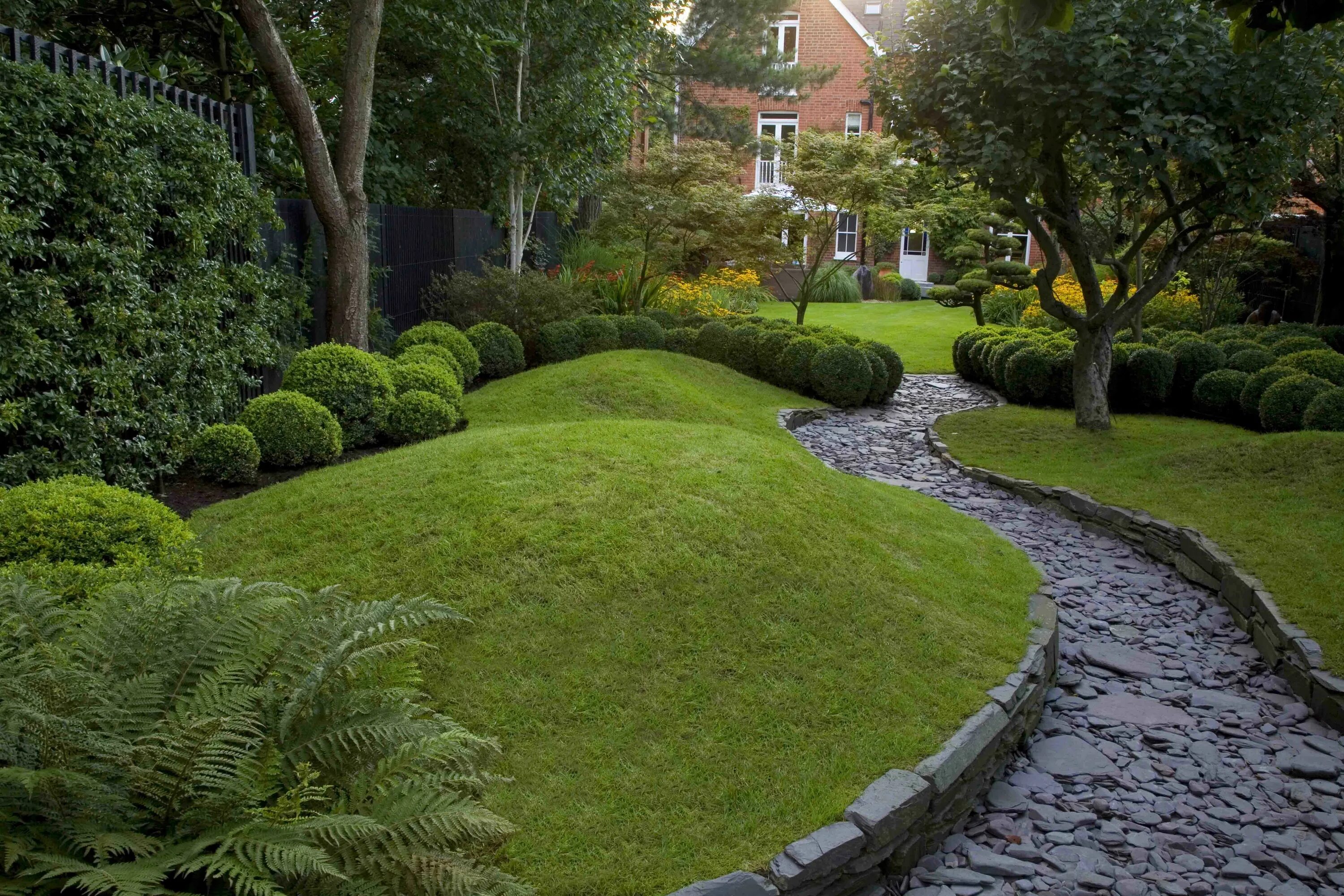 Правильный сад фото Shaded grey path surrounded by dark green: hedge, grass, trees, buxus and and fe