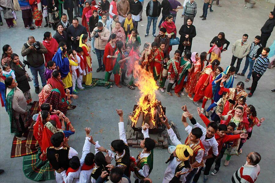 Праздники мира фото Girls in traditional attire dance around a bonfire as they celebrate Lohri festi