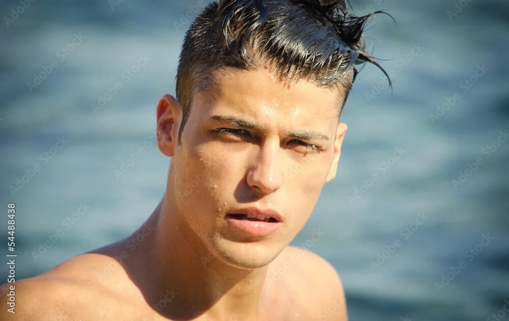 Прическа эффект мокрых волос мужская Handsome young man getting out of water with wet hair фотография Stock Adobe Sto