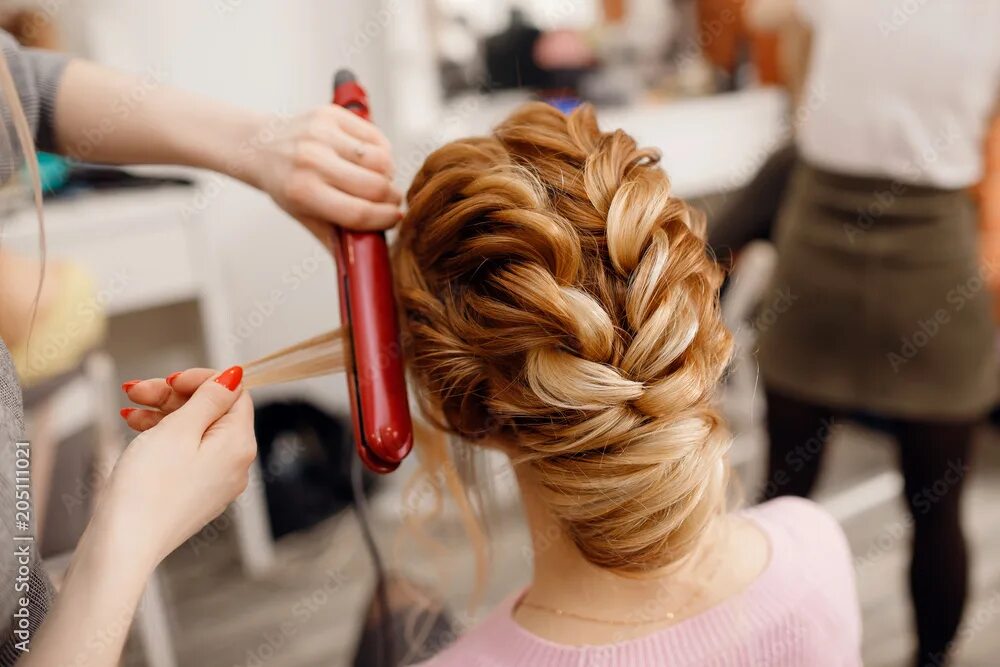 Прическа на средние волосы парикмахерская Woman hairdresser making hairstyle to blonde girl in beauty salon. Фотографія St