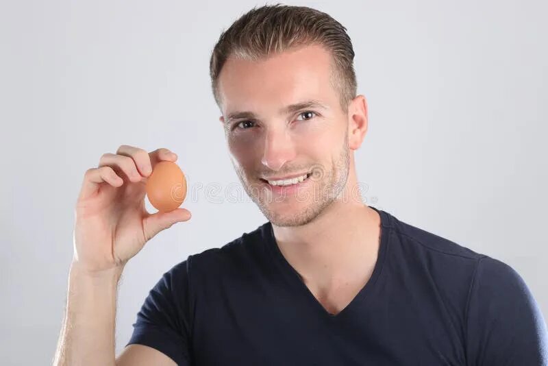 Прическа яйцо мужская Handsome Blond Man on Smiling Face Holding Egg in Studio Stock Image - Image of 