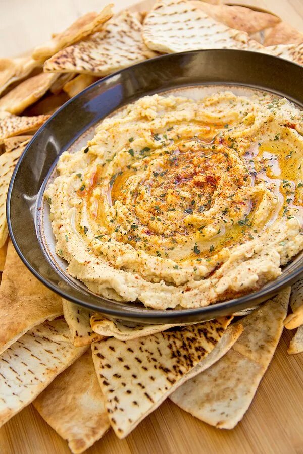 Приготовления хумуса фото Zesty Hummus Dip with Lemon and Garlic served with Homemade Baked Pita Wedges Re