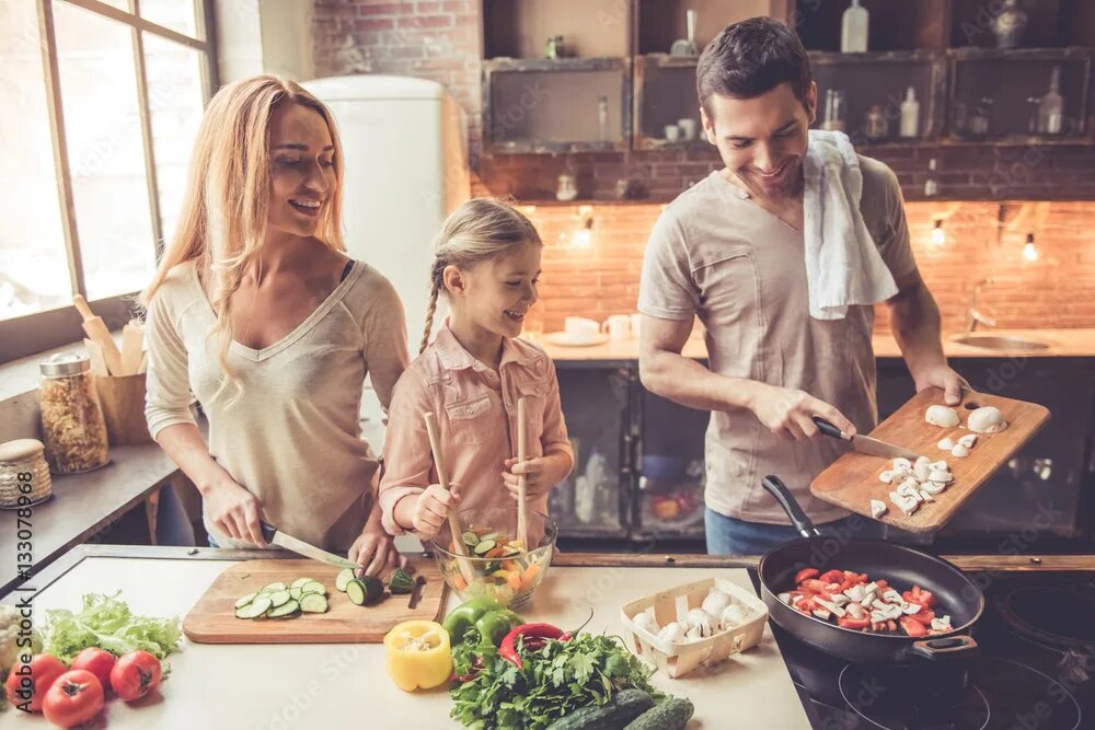 Приготовлю своим домашним Young family cooking Фотографія Stock Adobe Stock