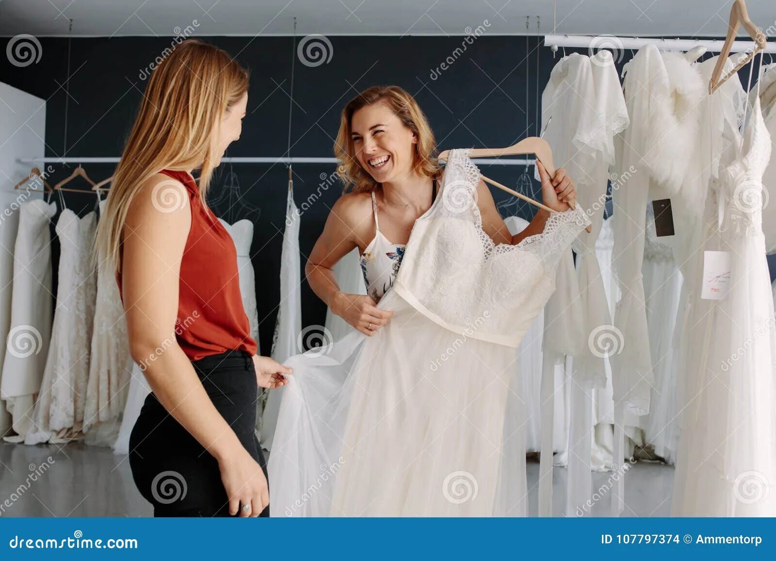 Приснилось что одевала платье Store Assistant Helps the Bride in Choosing Perfect Attire Stock Photo - Image o