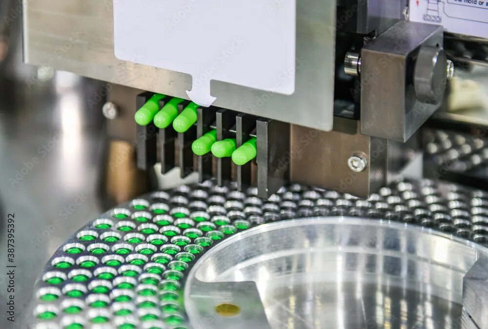 Производство таблеток фото Green capsule medicine pill production line, Industrial pharmaceutical concept. 