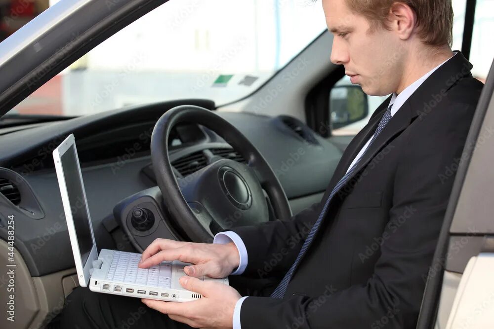 Проверка фото машина Businessman using laptop in his car Stock-Foto Adobe Stock