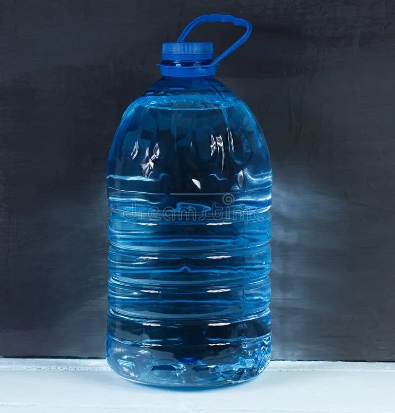 Пятилитровая бутылка воды фото 5 Liters. Big Plastic Bottle of Potable Water on a Dark Background. Stock Image 