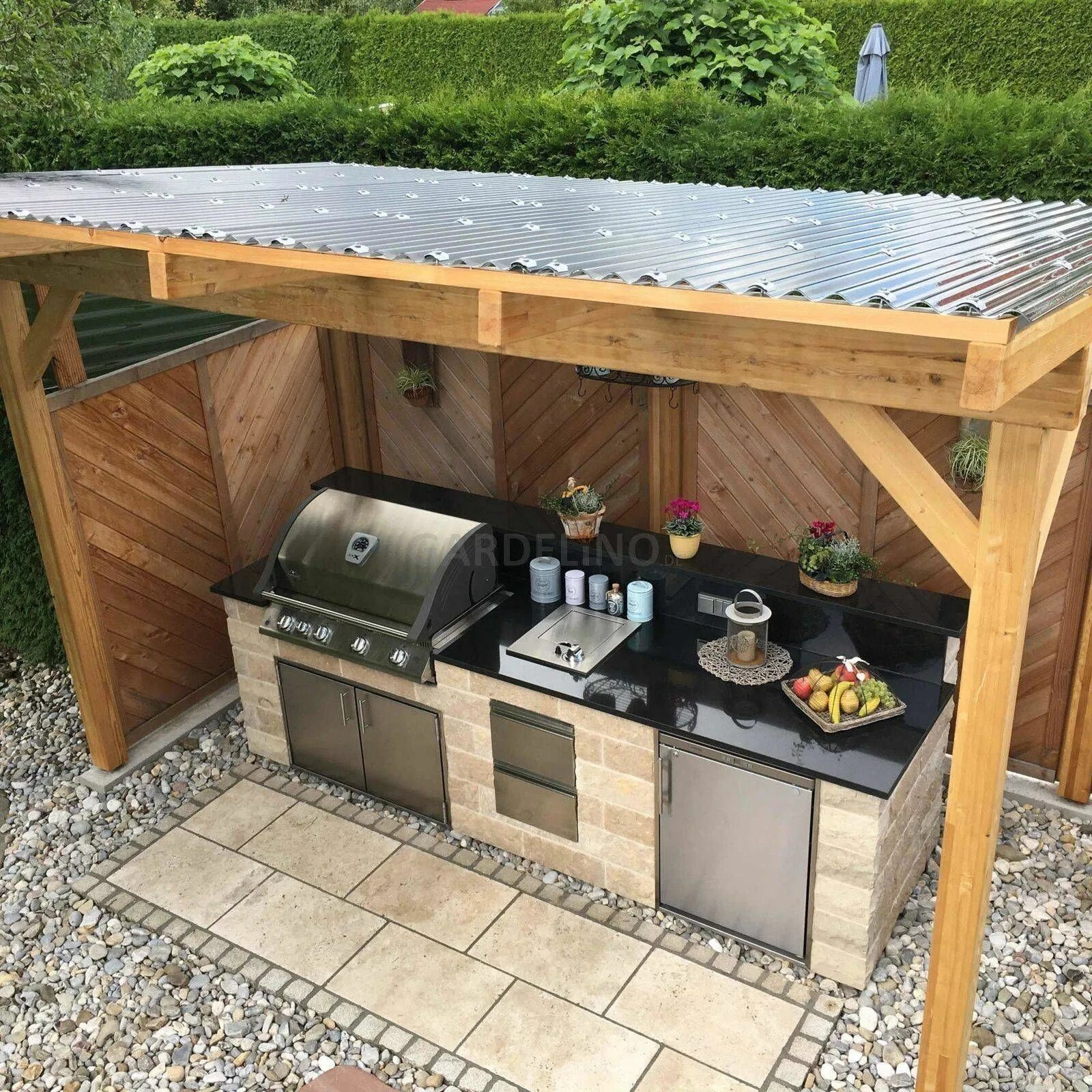 a relaxed rustic bbq zone of wood and concrete, with many potted herbs and a gri