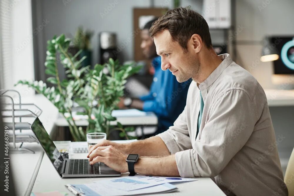 Работа с фото для начинающих Side view portrait of smiling adult man using laptop while enjoying work in offi