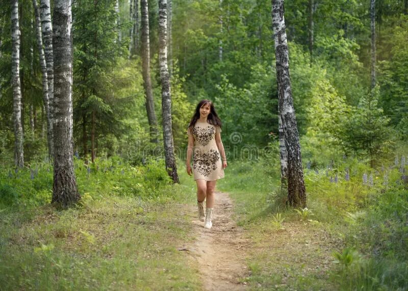 Раздели в лесу фото Young Girl Stands Knee-deep in the Water of a River and Squeezes a Wet Dress Sto