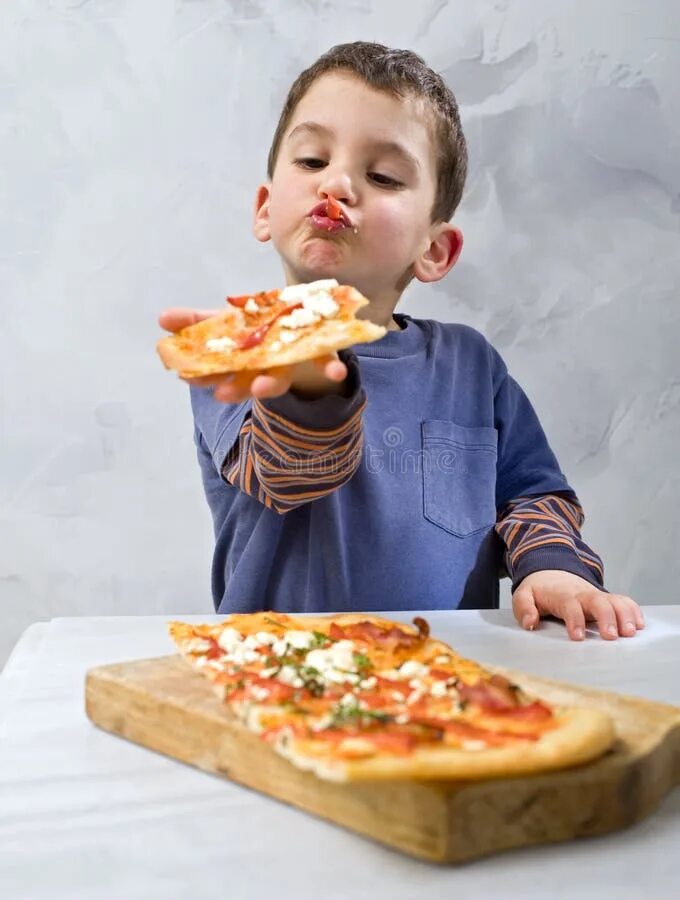 Ребенок пицца фото Young boy eating pizza stock photo. Image of anticipation - 8667196