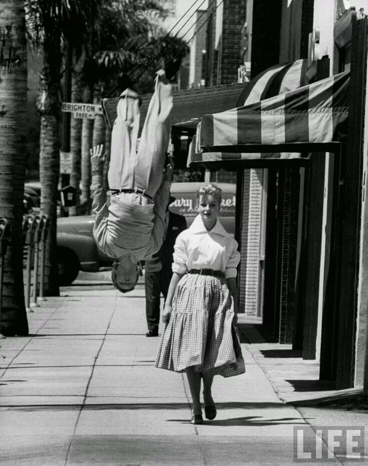 Редкие ретро фото Acrobat and actor Russ Tamblyn does a flip on the sidewalk while walking with mo