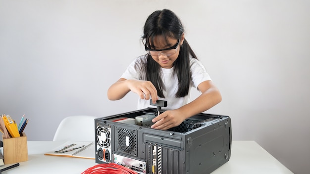 Ремонт девушки своими руками Premium Photo A little girl is repairing computer hardware at the white working 