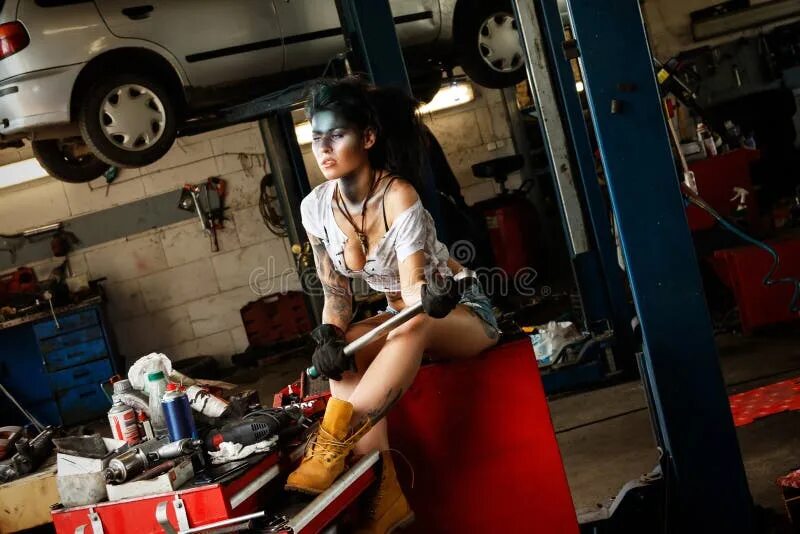 Ремонт девушки своими руками Female Mechanic in the Garage with Artistic Makeup on Her Face Stylized Like a D