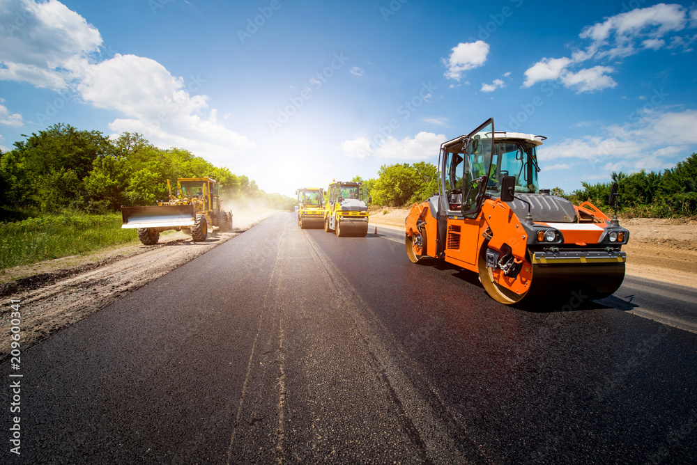 Ремонт дорог фото industrial landscape with rollers that rolls a new asphalt in the roadway. Repai